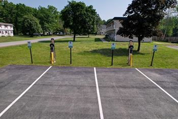A parking lot with four parking meters.